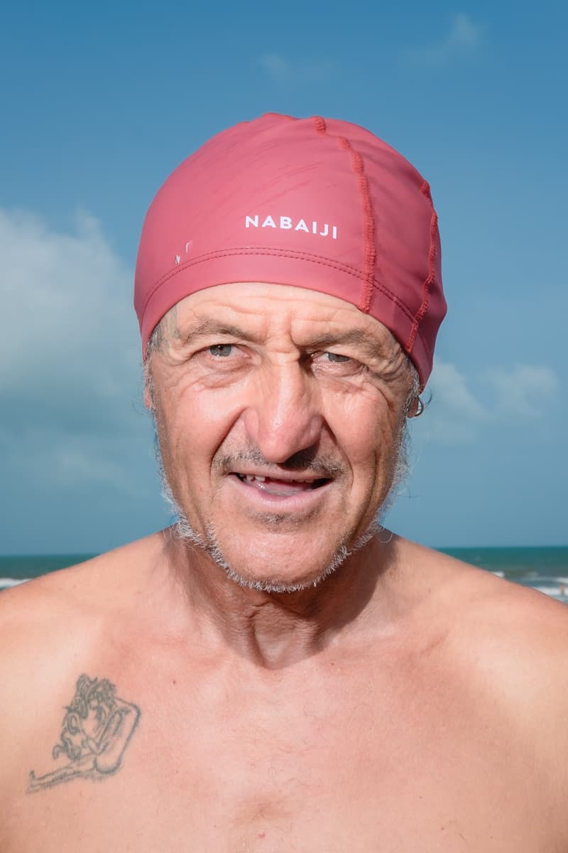 Portrait of a swimmer wearing a pink swim cap on a beach